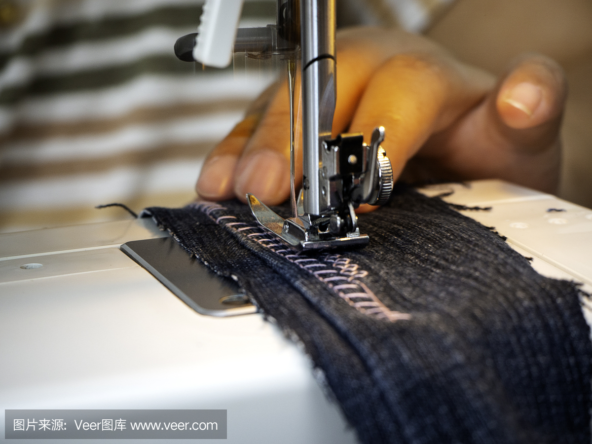 穿戴制造的概念。女性的双手在缝纫机上工作